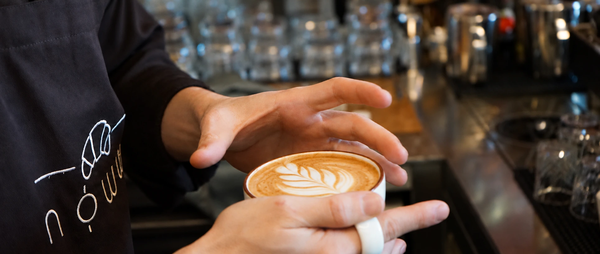 Noww baristasının elinde tuttuğu latte ve doğal latte art